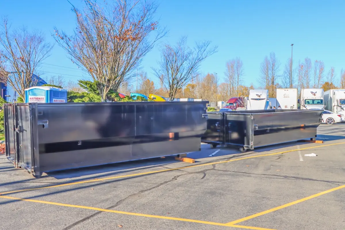Professional dumpster rental service with roll-off container on residential driveway in Algona
